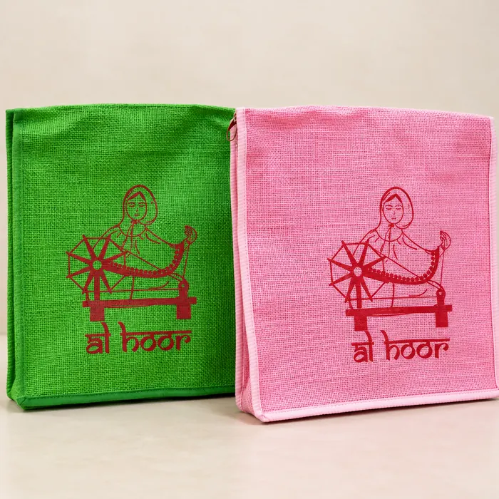 Green and pink jute bags screen printed with a red charkha design